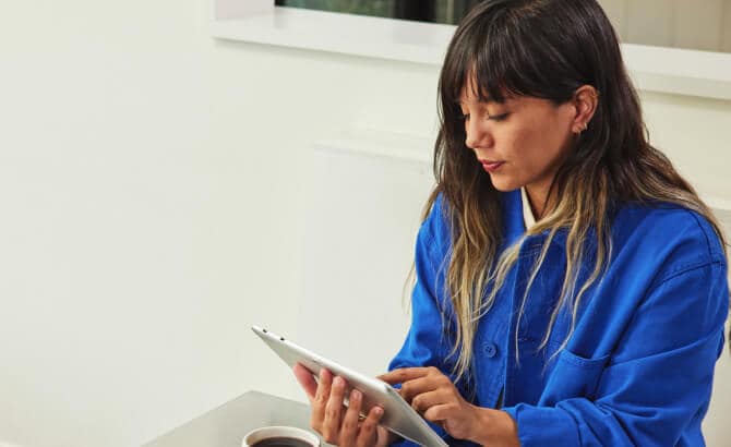 Una giovane donna al tavolo con un tablet